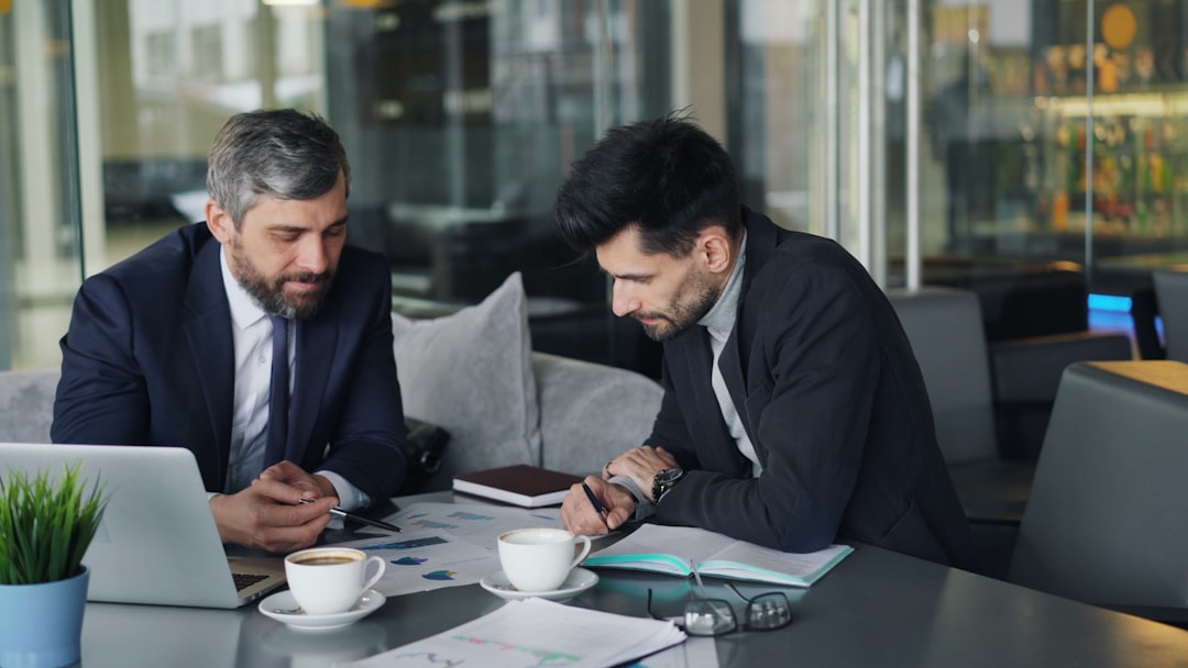 Dos profesionales de Gestoría G1 revisan documentos y gráficos para cambiar de gestoría sin complicaciones