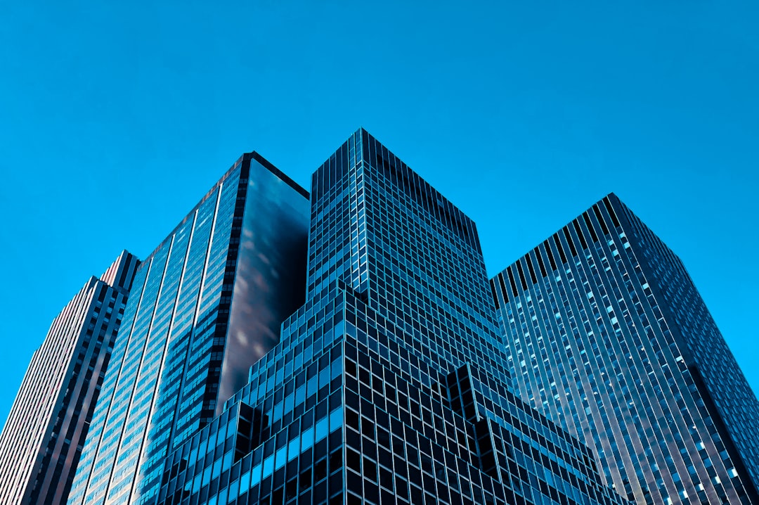 Gestoría G1 explica la escisión de sociedades ante rascacielos de cristal que simbolizan grandes estructuras empresariales