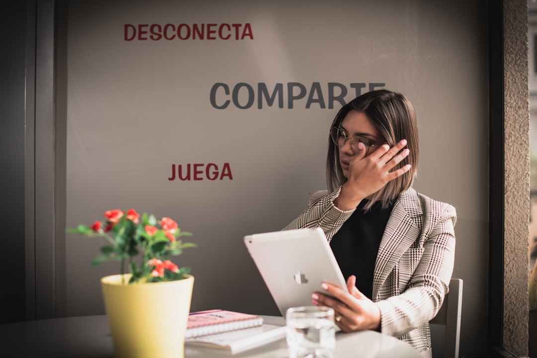 Woman checking the deadlines for applying for unemployment benefits on a tablet, advised by Gestoría G1 from her office